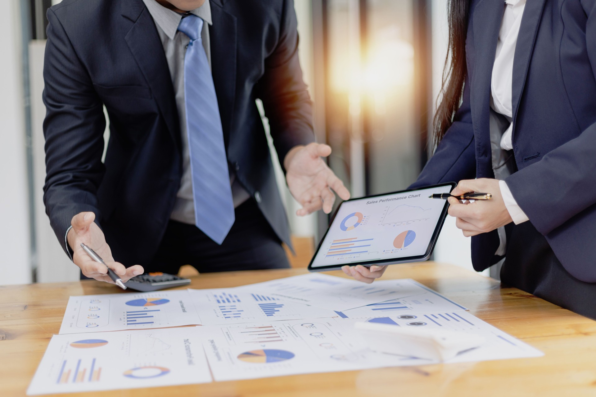 Business partners working with analysis report and advisor showing plan.